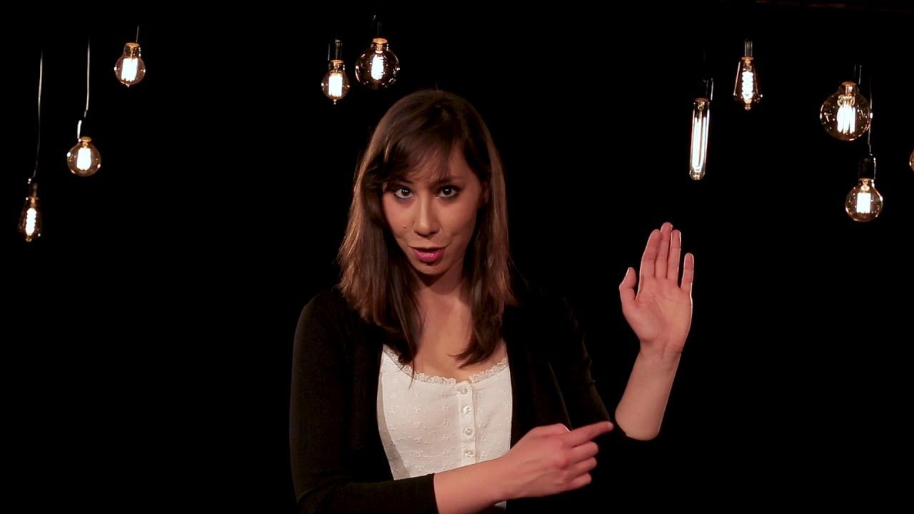 Image of a woman with mid length dark hair in a room with hanging lightbulbs