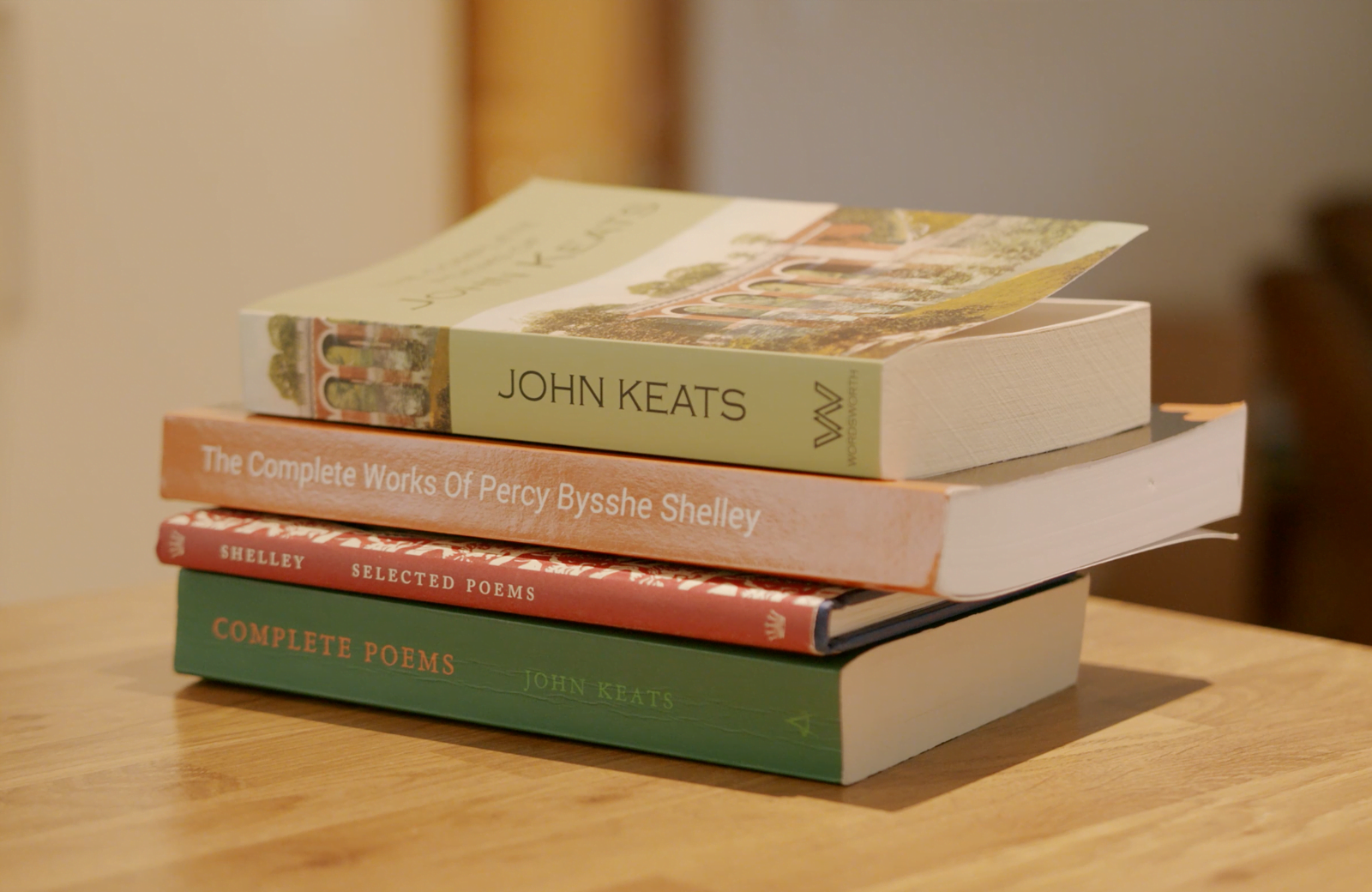 A stack of books from John Keats on a table